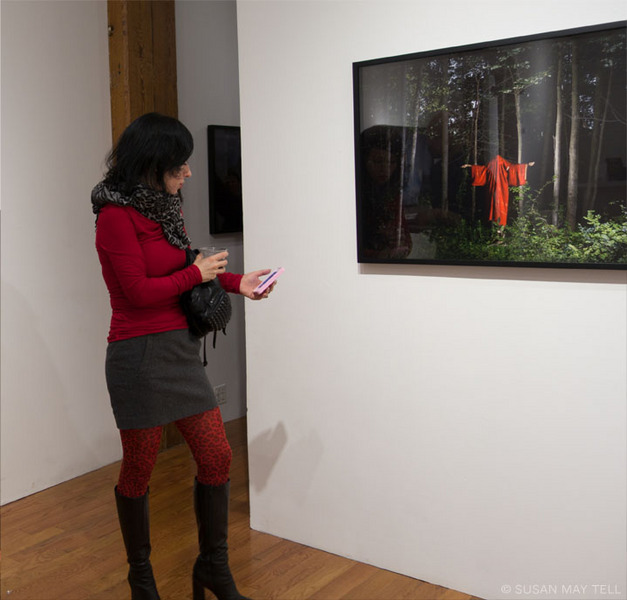 A guest in front of Miyamo Lake's photograph Layered Solitude #1 at the holiday toast, Miyako Yoshinaga Gallery, 2014. Photo © Susan May Tell